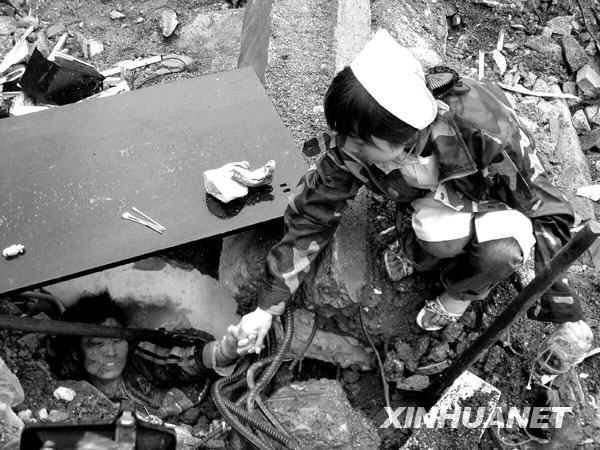 2008年5月13日，北川，一位护士不停地与一位被困孩子说话，鼓励他坚强活下去，等待救援。