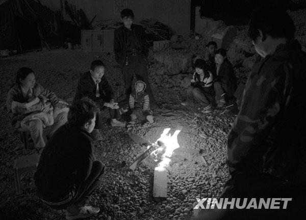 2008年5月13日凌晨，几位陇南受灾群众在烤火取暖。