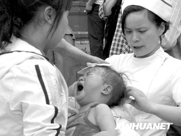 2008年5月12日14时43分，医务人员在都江堰市人民医院门前救护受伤的婴儿。