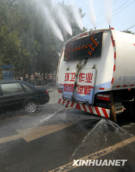 6月24日，在河北省邢台市街头，环卫洒水车上路作业，给道路洒水降温。